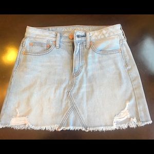 Distressed jean skirt with frayed bottom.